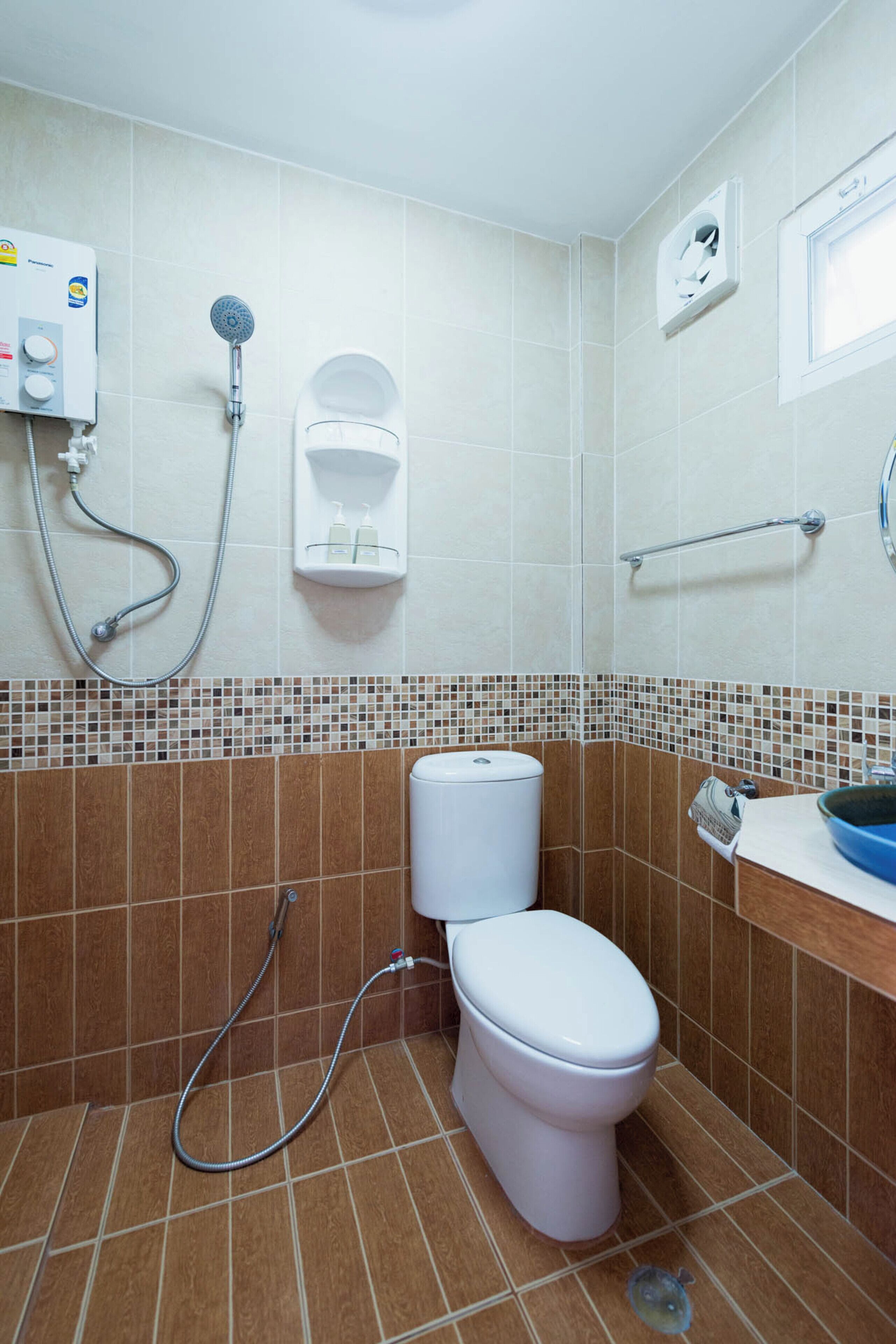 Een badkamer met toilet, douche en wastafel.