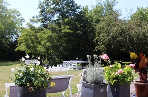 Outdoor seating with potted plants. - Rosengaarden Hostel (Akirkeby)
