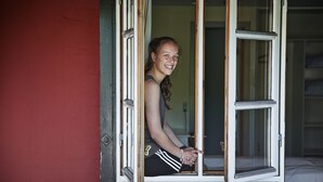 A person sitting by a window with white trim and a wooden frame. - Rosengaarden Hostel (Akirkeby)