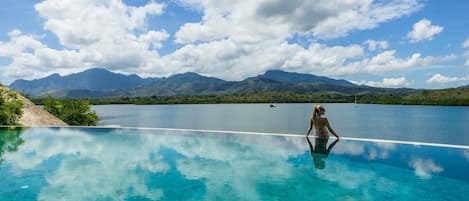 Alberca al aire libre, sombrillas en la alberca y camastros