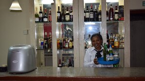 Un espace bar avec des étagères remplies de différentes bouteilles d’alcool.