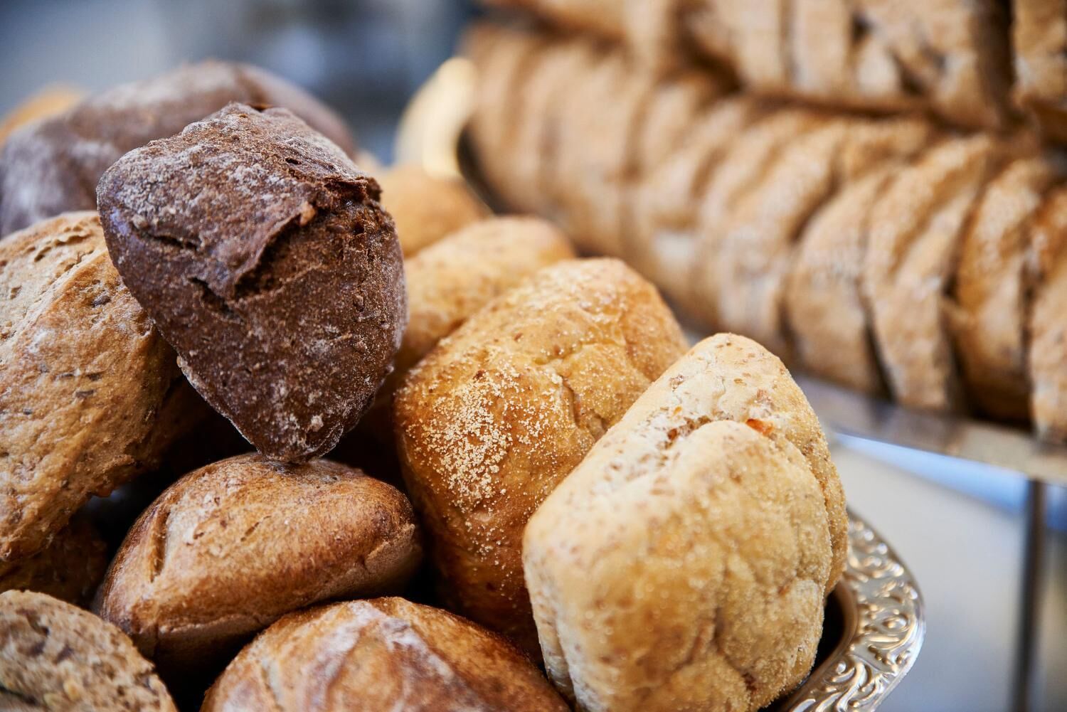 Eine Auswahl an Brot und Gebäck in einem Metalleimer.