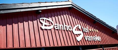 Ein rotes Gebäude mit einem Schild, auf dem 'Danho S. vaneke' steht.