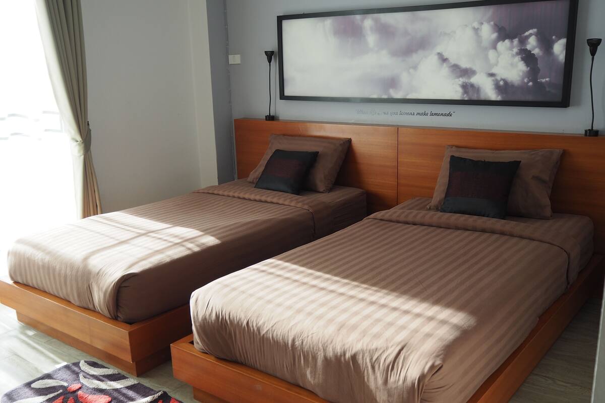 A double bed with a headboard, a bedside table, and a wall-mounted TV.