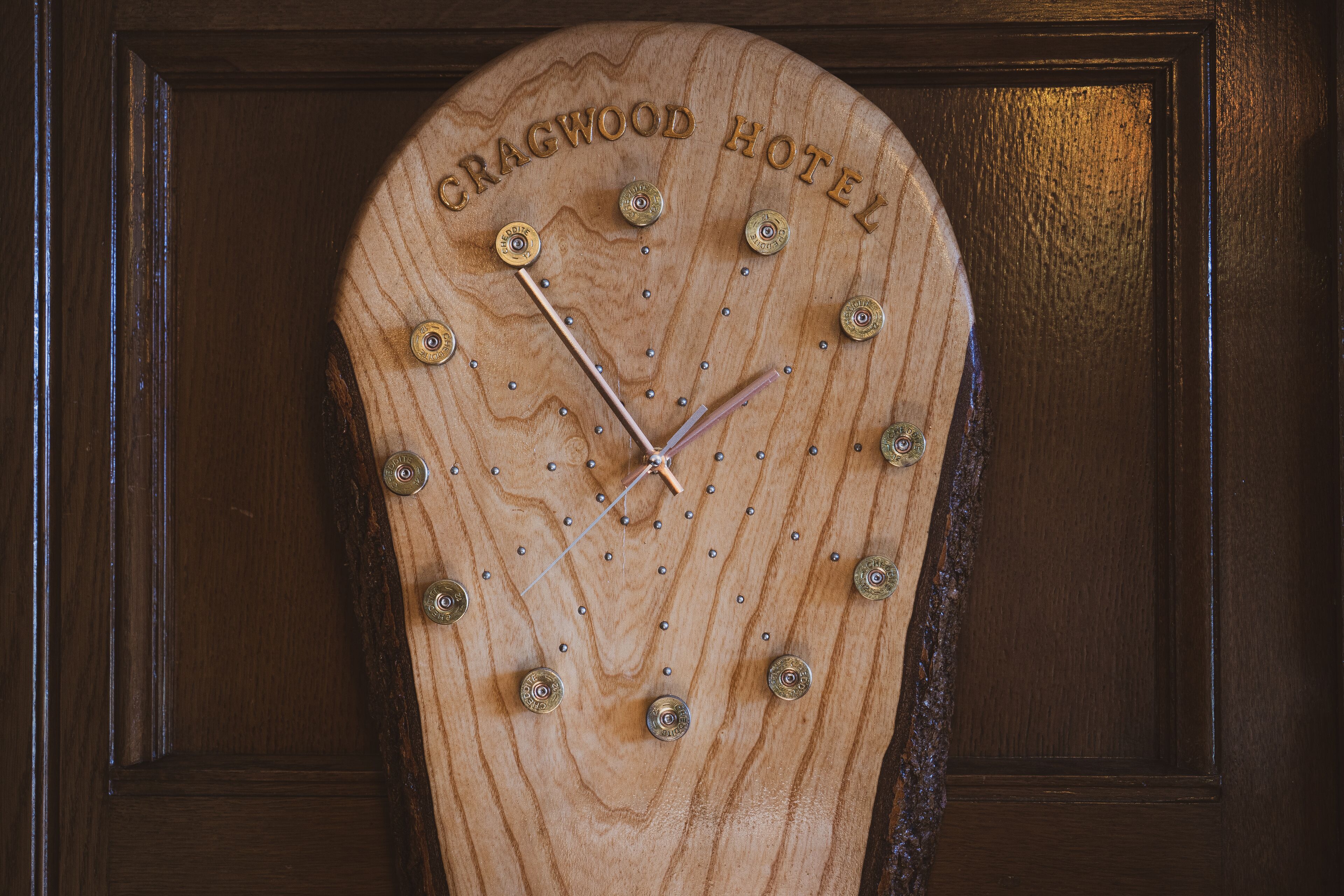 A wooden clock with the text "CRAGWOOD HOTEL" on it.