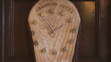 A wooden clock with the text "CRAGWOOD HOTEL" on it.