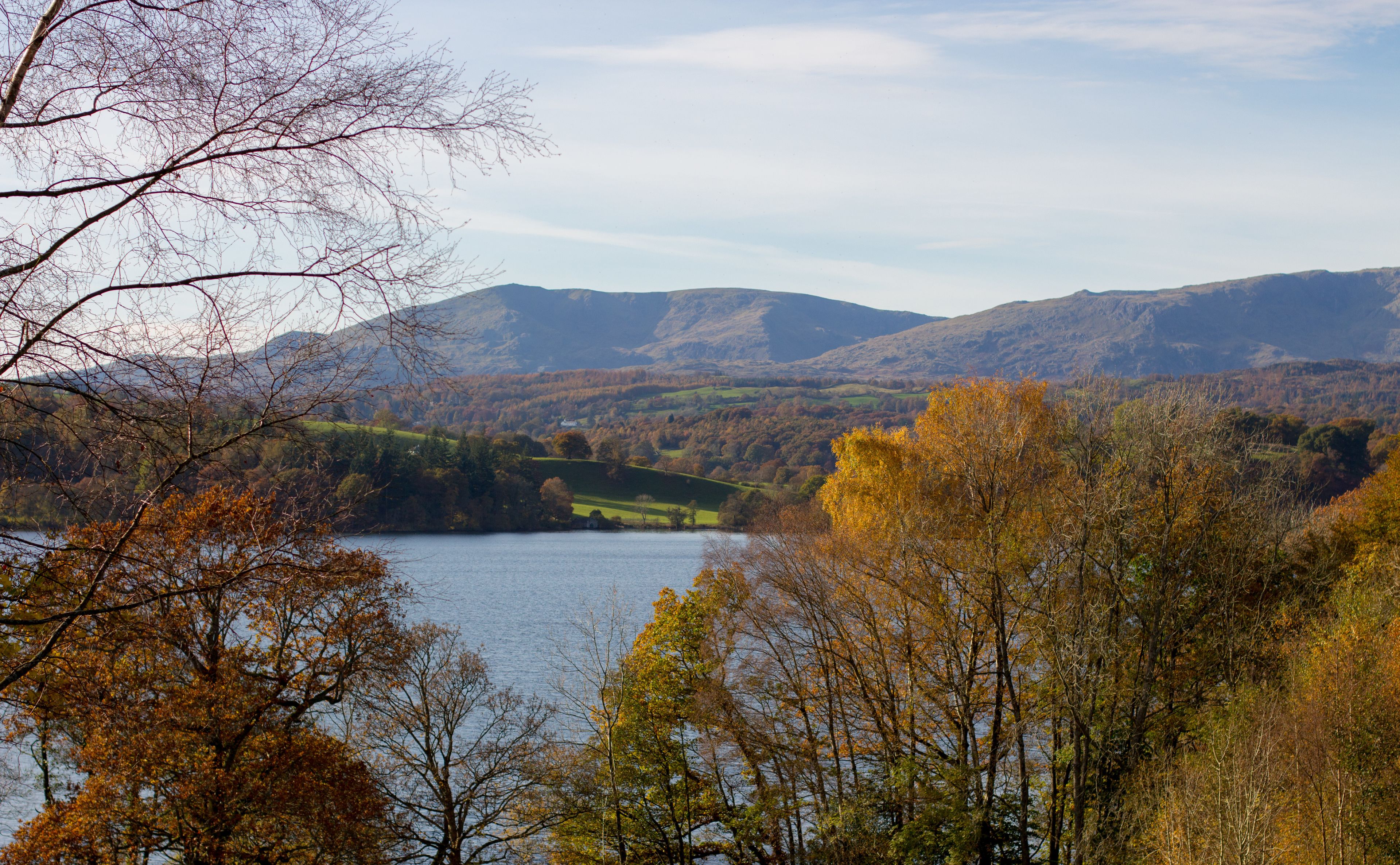 A lake surrounded by autumn-colored trees and hills.