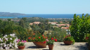 A terrace with potted plants and a view of a coastal town. - Li Muntigeddi (San Teodoro)