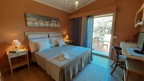 A hotel room with a bed, bedside lamps, a desk with a computer, and a view of the outdoors. - Li Muntigeddi (San Teodoro)