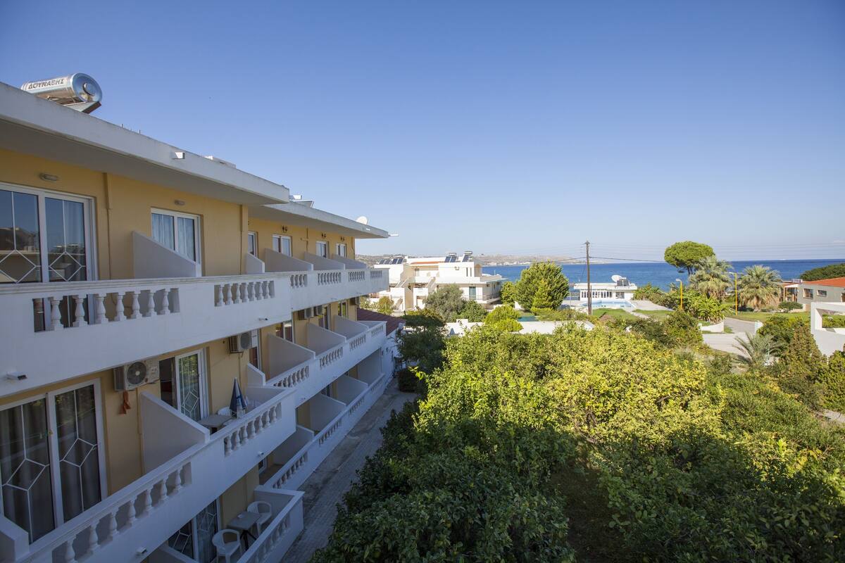 A multi-story hotel with balconies overlooking a coastal area.