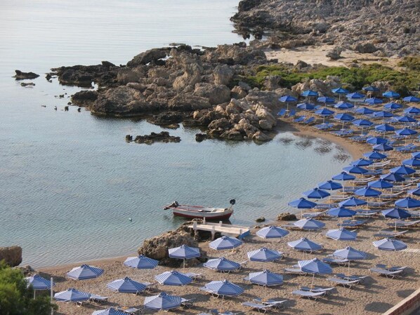 Una playa cerca, sillas reclinables de playa, sombrillas