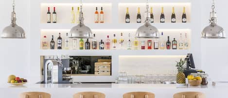 A bar area with multiple shelves of liquor bottles, a kitchen counter, and four wooden chairs.