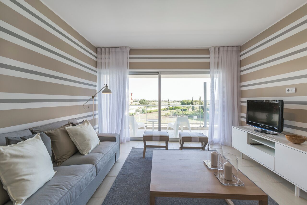Una sala moderna con un sofá, una mesa de centro y una televisión.