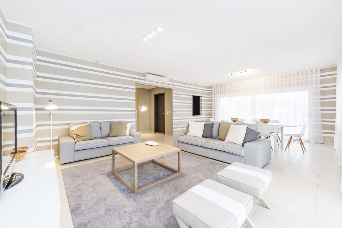 Un salon moderne avec deux canapés, une table basse et un coin repas.