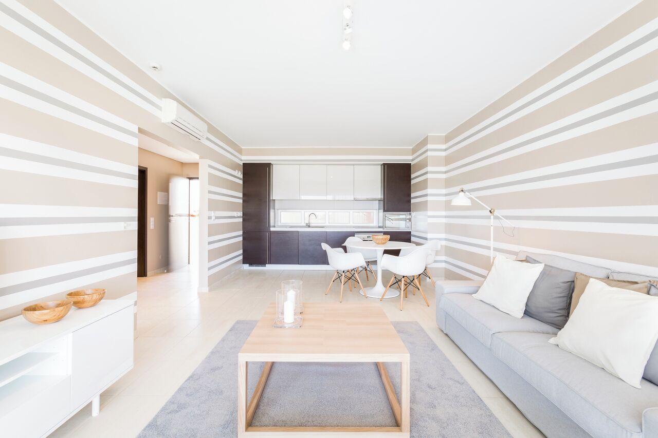 Un salon moderne avec un canapé, une table basse et un coin repas.