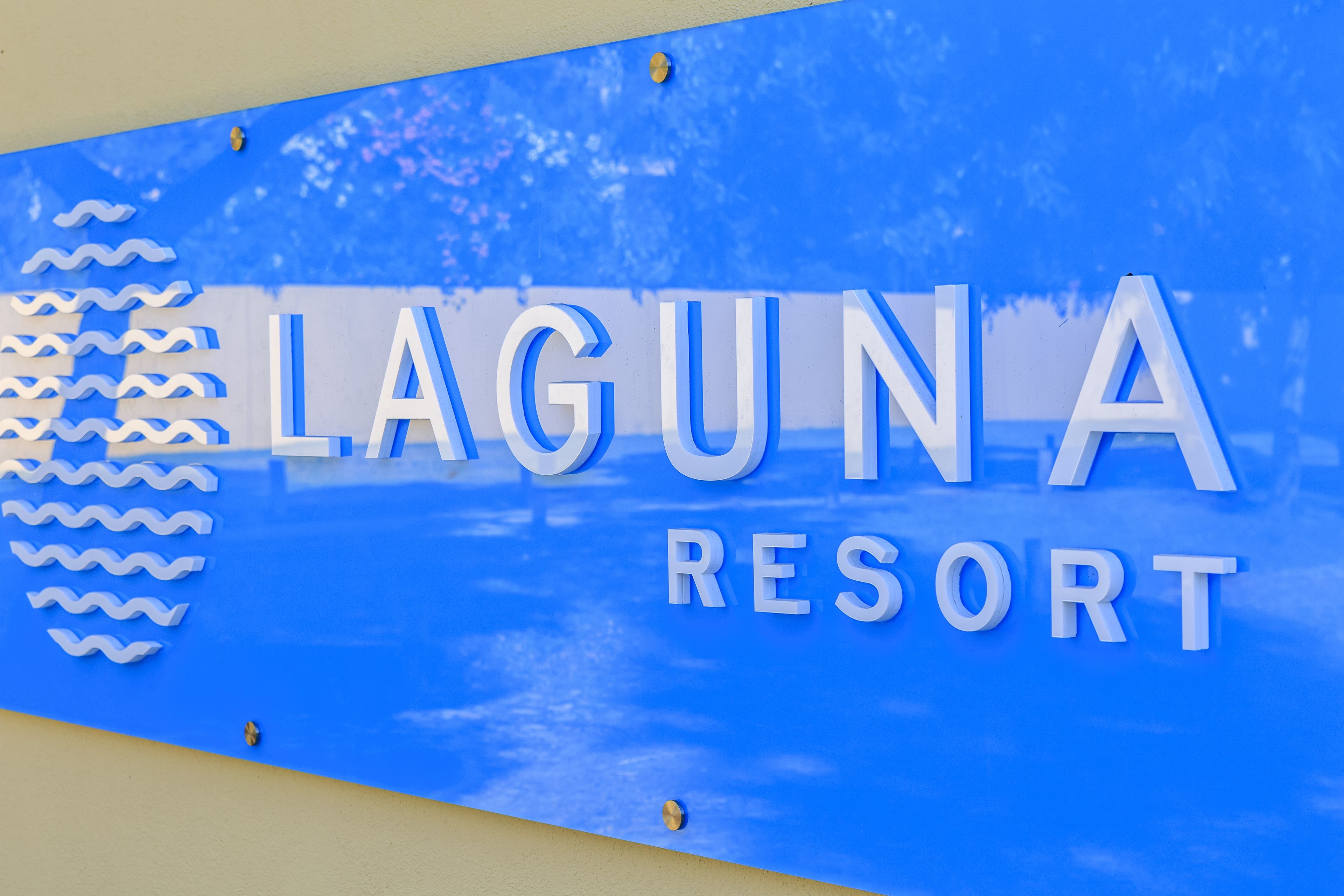 A sign for Laguna Resort with a blue background and white lettering.