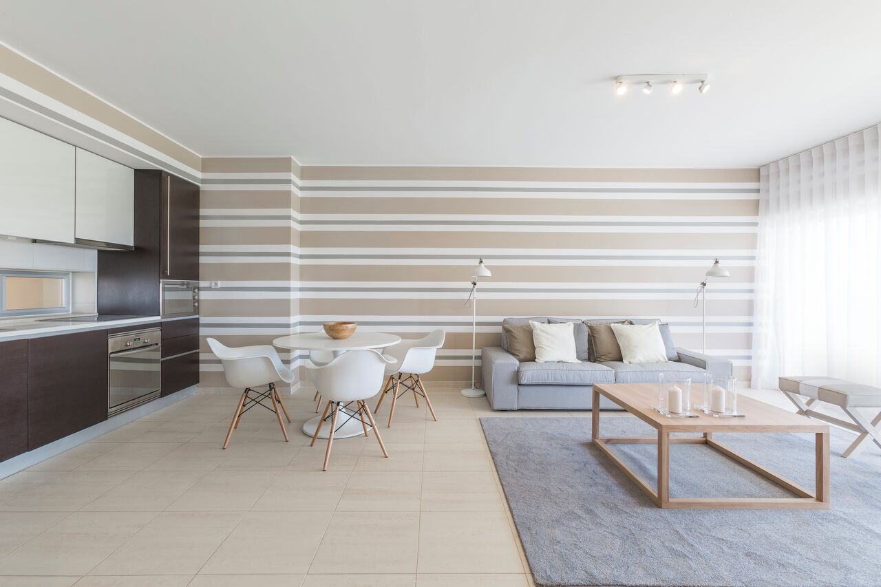 A modern living room with a sofa, coffee table, and dining area.