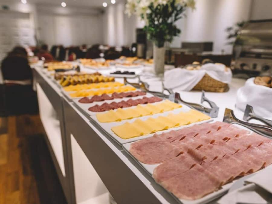A buffet with various meats and cheeses.