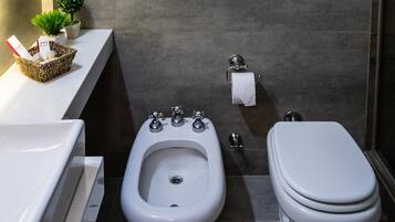 A modern bathroom with a bidet, toilet, and sink.