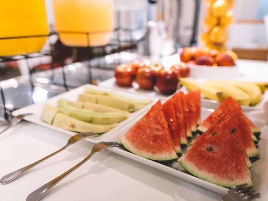 A breakfast buffet with sliced fruits and vegetables.