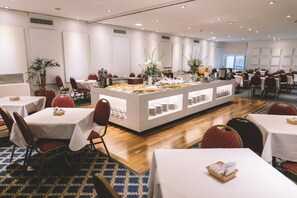 Enjoy a meal in our dining area, featuring a central buffet station and comfortable seating.