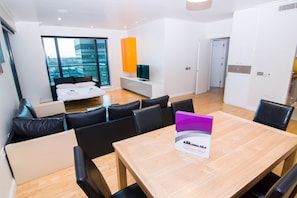 Apartamento panorâmico, 2 quartos, 2 banheiros, vista para o rio | Sala de estar | TV de tela plana