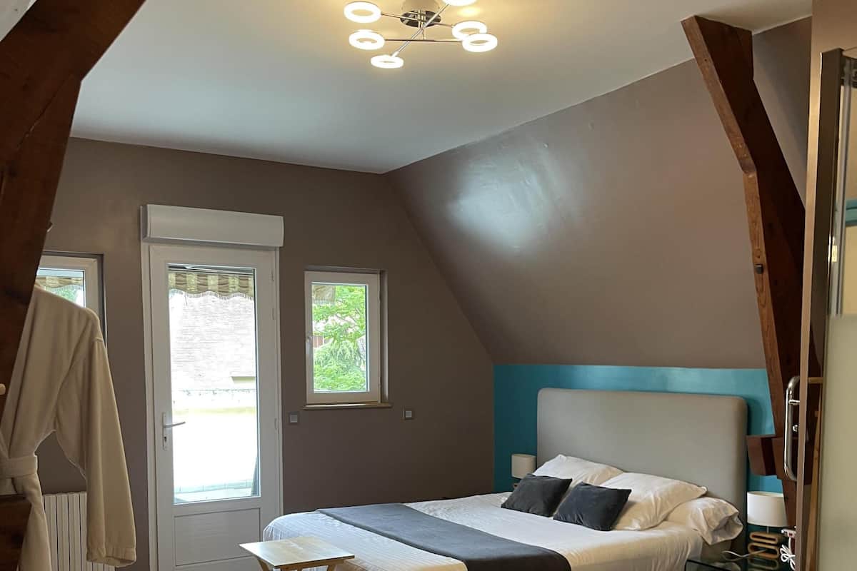A bedroom with a bed, bedside table, and a ceiling light fixture.