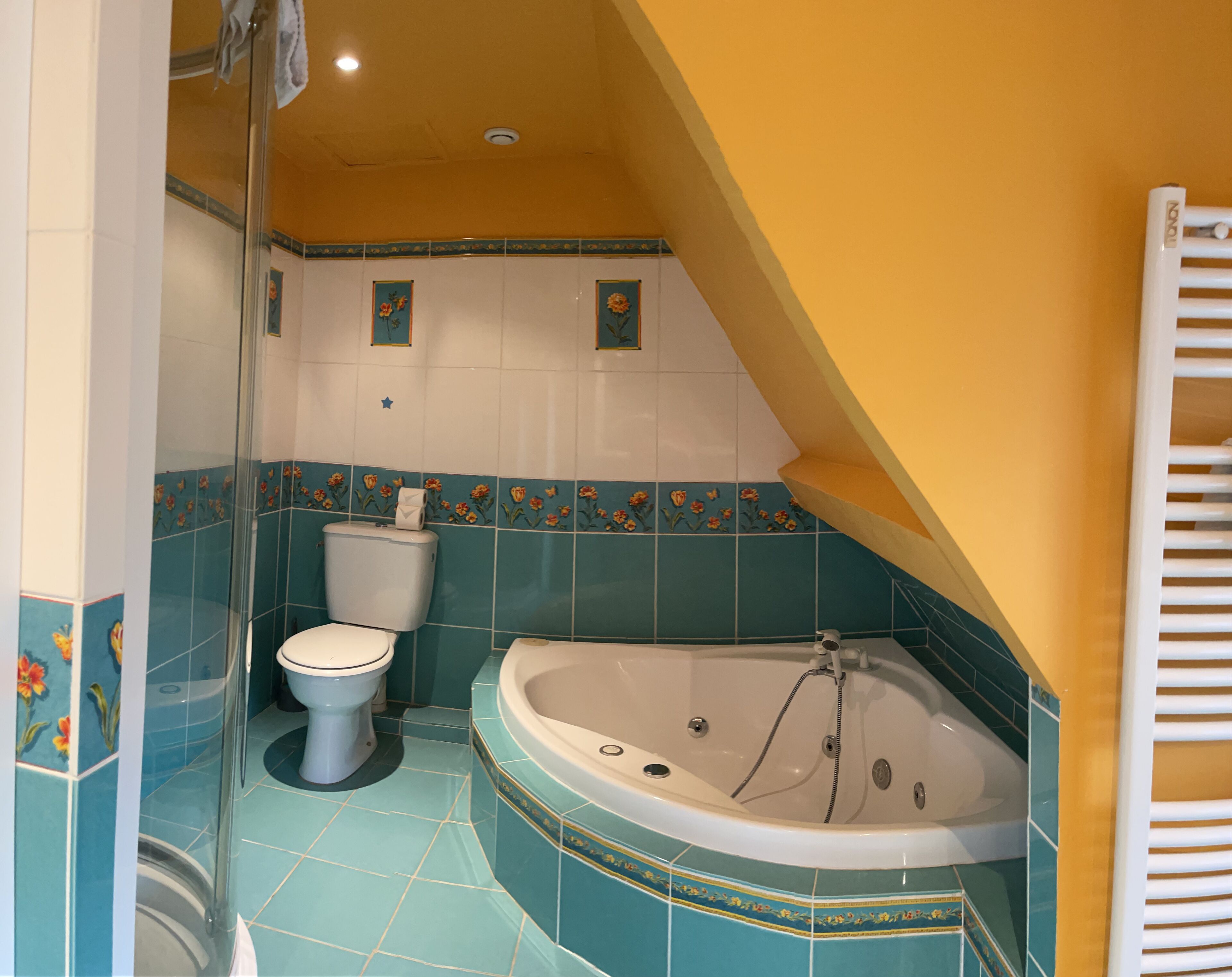 Een badkamer met een toilet, een badkuip en een douche.