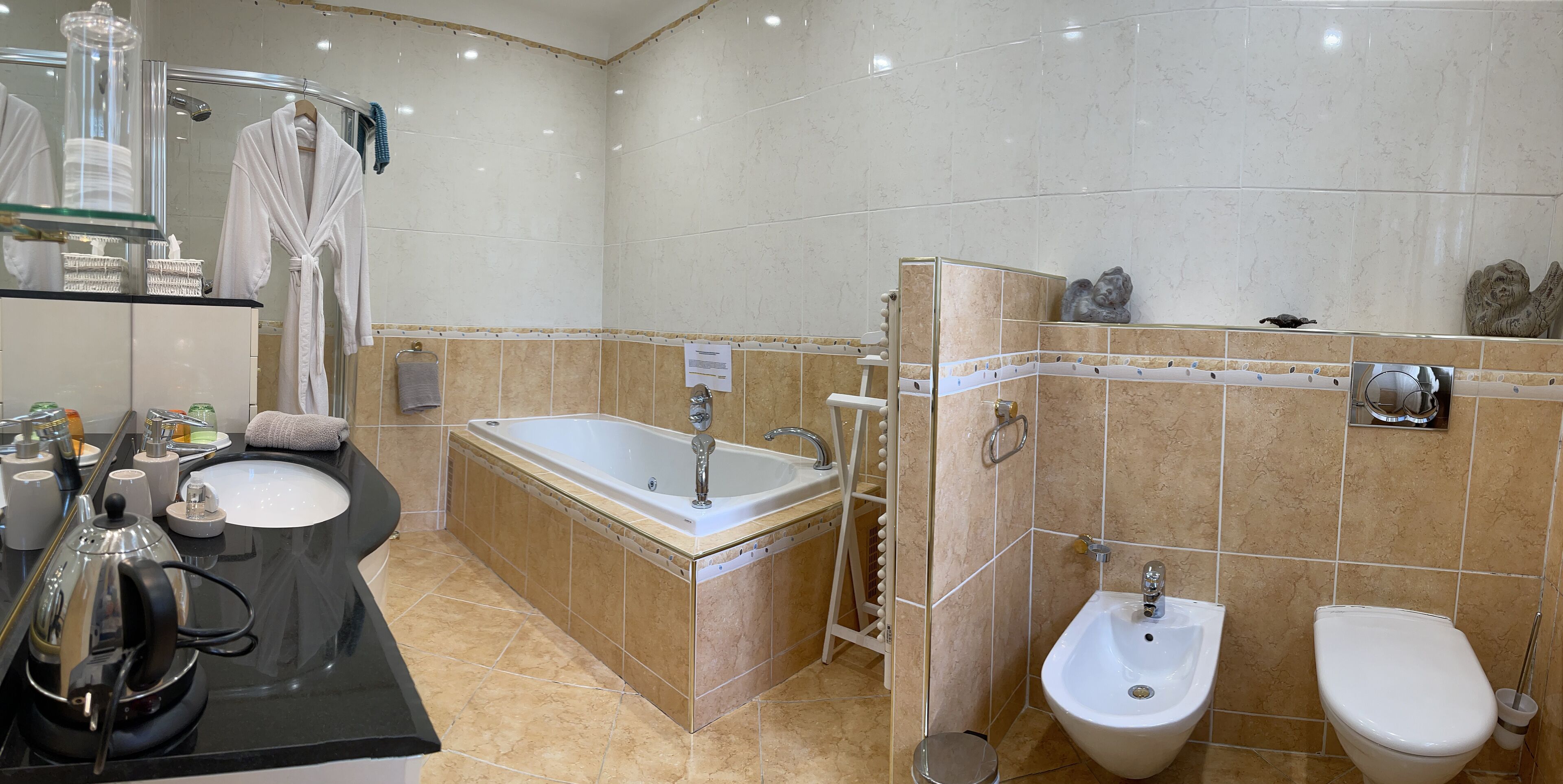 Een moderne badkamer met een bad, een wastafel en een toiletbril met douchefunctie.