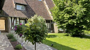 A traditional house with a stone pathway leading to the entrance, surrounded by a well-maintained garden with various plants and flowers. - La Collinière (Sainte-Gemme-Moronval)