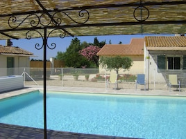 Una piscina al aire libre de temporada, sombrillas