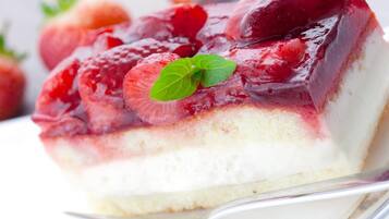 Una porción de postre en capas con fresas y una hoja de menta como decoración.