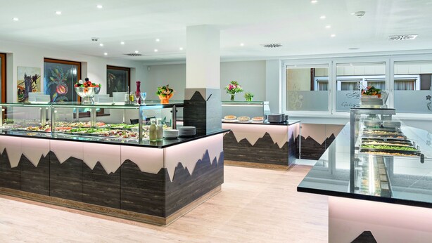 A buffet area with a modern design, featuring a central island with a mountain-like pattern on the sides. - Hotel Thüringenschanze (Oberhof)