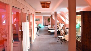 A hotel corridor with wooden walls, a tiled floor, and a seating area with chairs and a table. - Hotel Thüringenschanze (Oberhof)