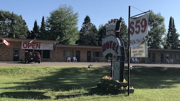 Un motel con un letrero que anuncia habitaciones a 59 dólares, WiFi gratuito y aire acondicionado.