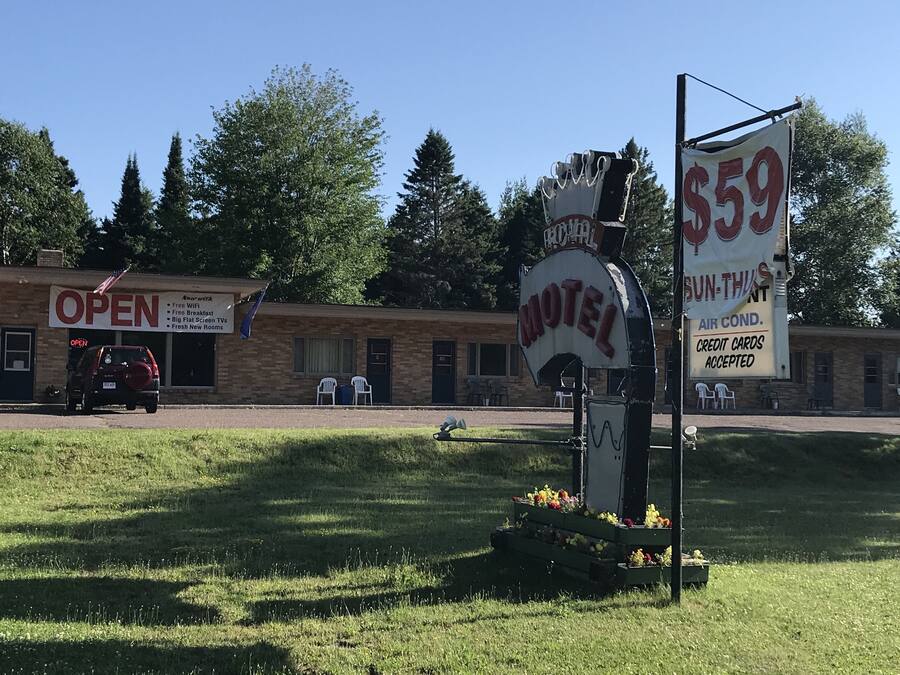 Un motel con un letrero que anuncia habitaciones a 59 dólares, WiFi gratuito y aire acondicionado.