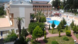 A hotel with a swimming pool, palm trees, and a view of the mountains. - Ares Dream Hotel- All Inclusive (Kemer)