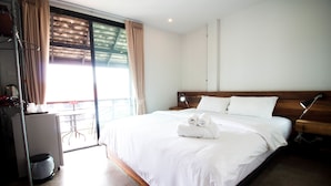 Habitación de hotel con una cama grande, un escritorio con silla y vistas al exterior.