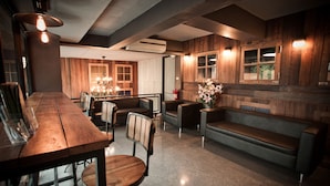 Un interior moderno con una mesa de comedor de madera, sillas, un sofá y una pequeña mesa con un florero.
