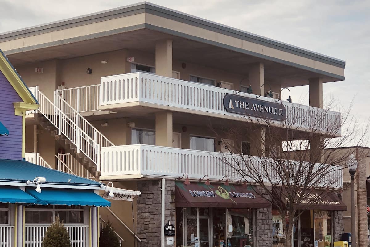 A multi-story building with balconies, a sign for "The Avenue II," and a storefront with a sign for "Lounge & Ice Cream."