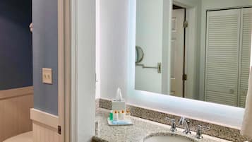 A bathroom with a white sink, a mirror, and a toilet.