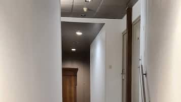 Una escalera alfombrada con barandilla que lleva a una puerta al final.