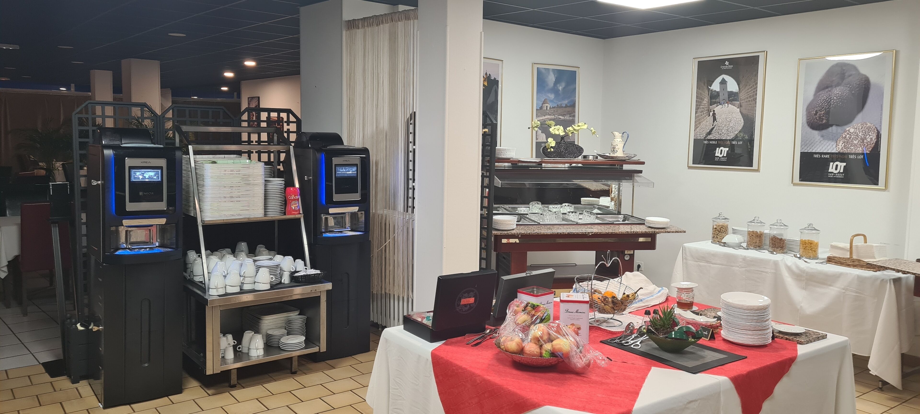 A buffet setup with a self-service kiosk, a variety of food items, and a table with plates and condiments.