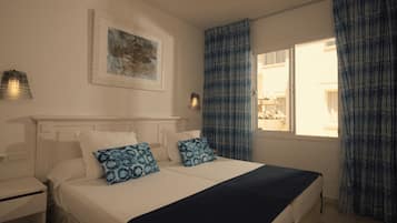 Een slaapkamer met een bed, nachtkastjes, een wandlamp, een raam met gordijnen en een lijst met een afbeelding.