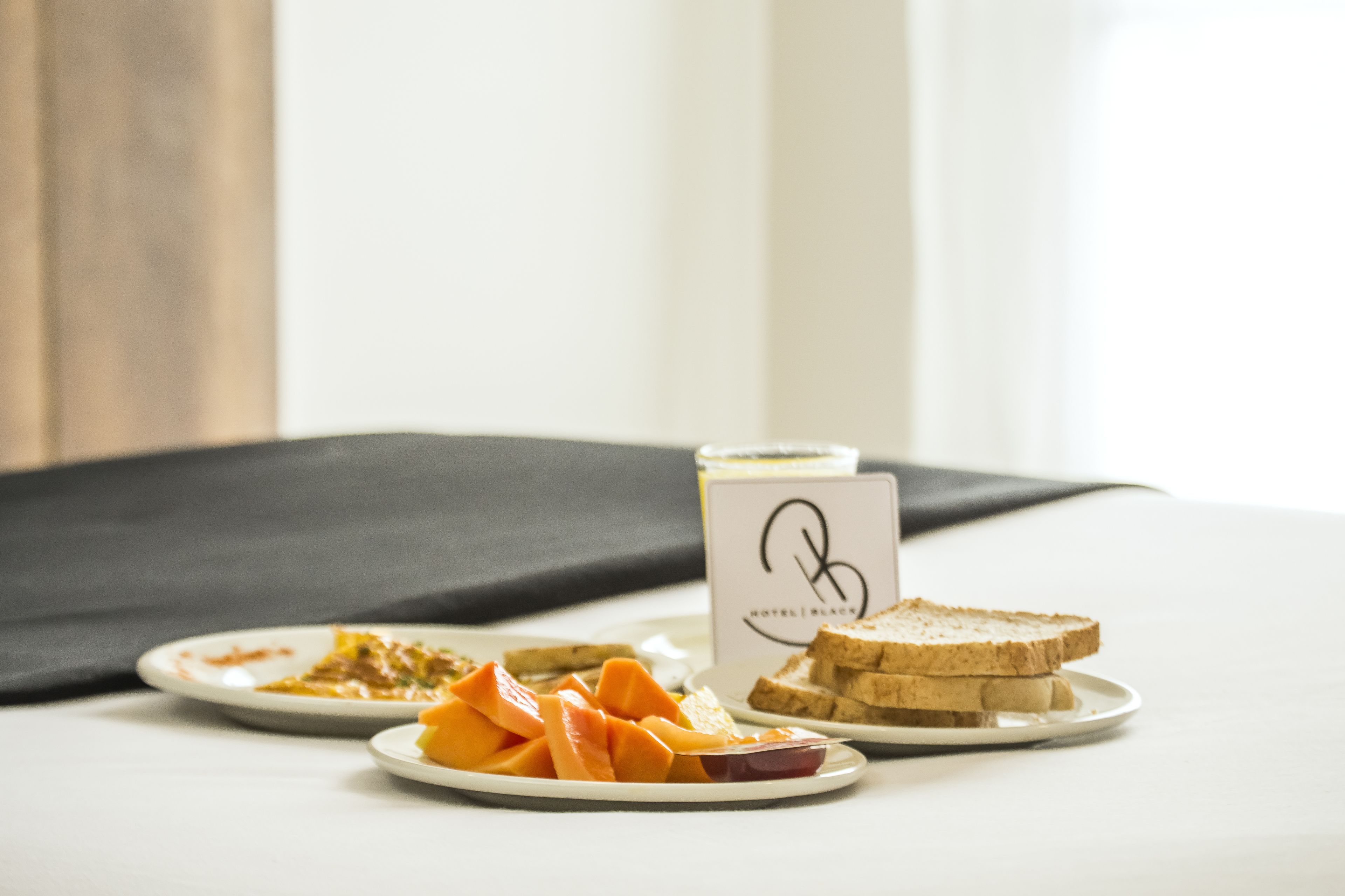 A table with plates of food, a candle, and a sign with a logo.