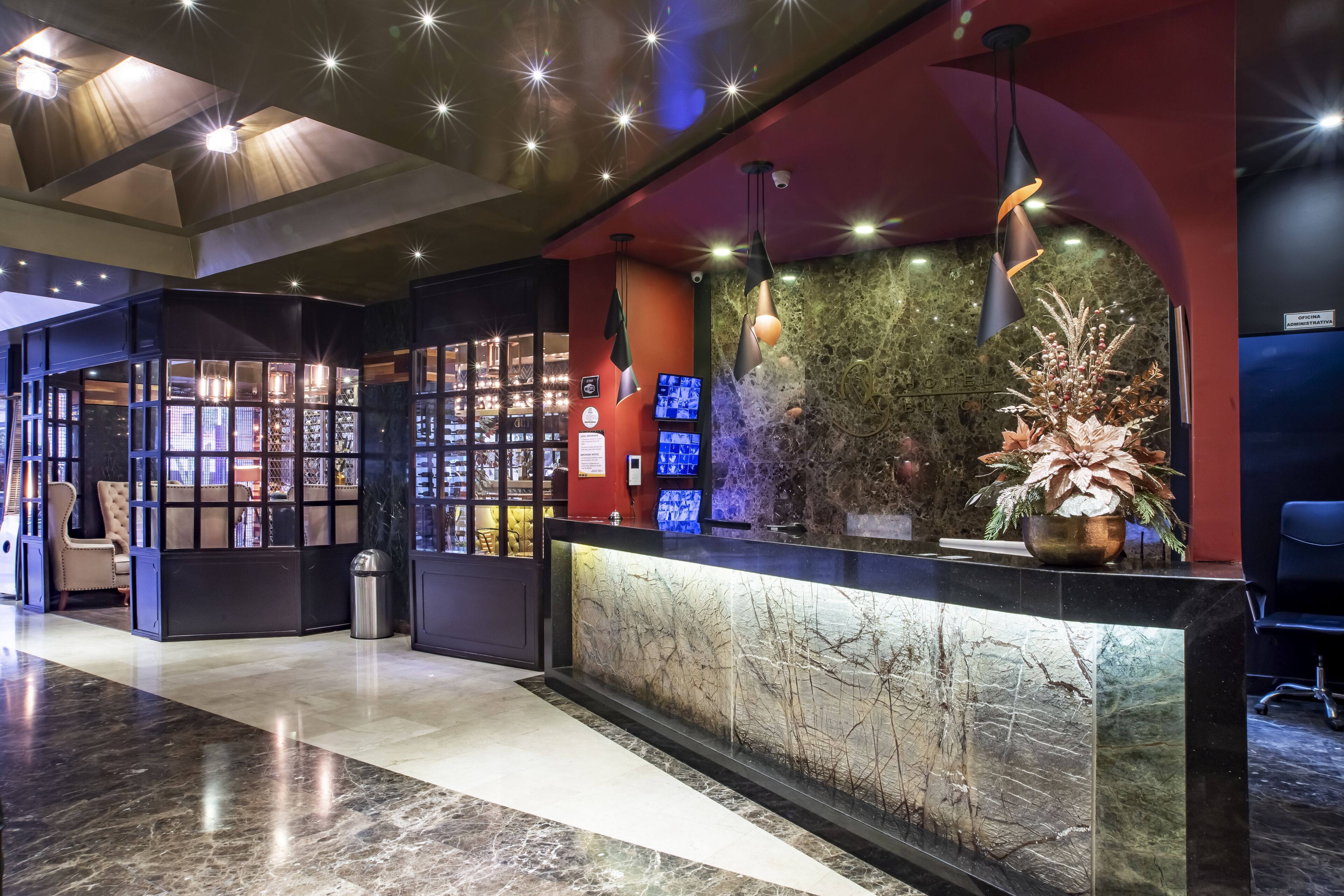 A modern reception area with a marble counter, a digital display, and a decorative plant.