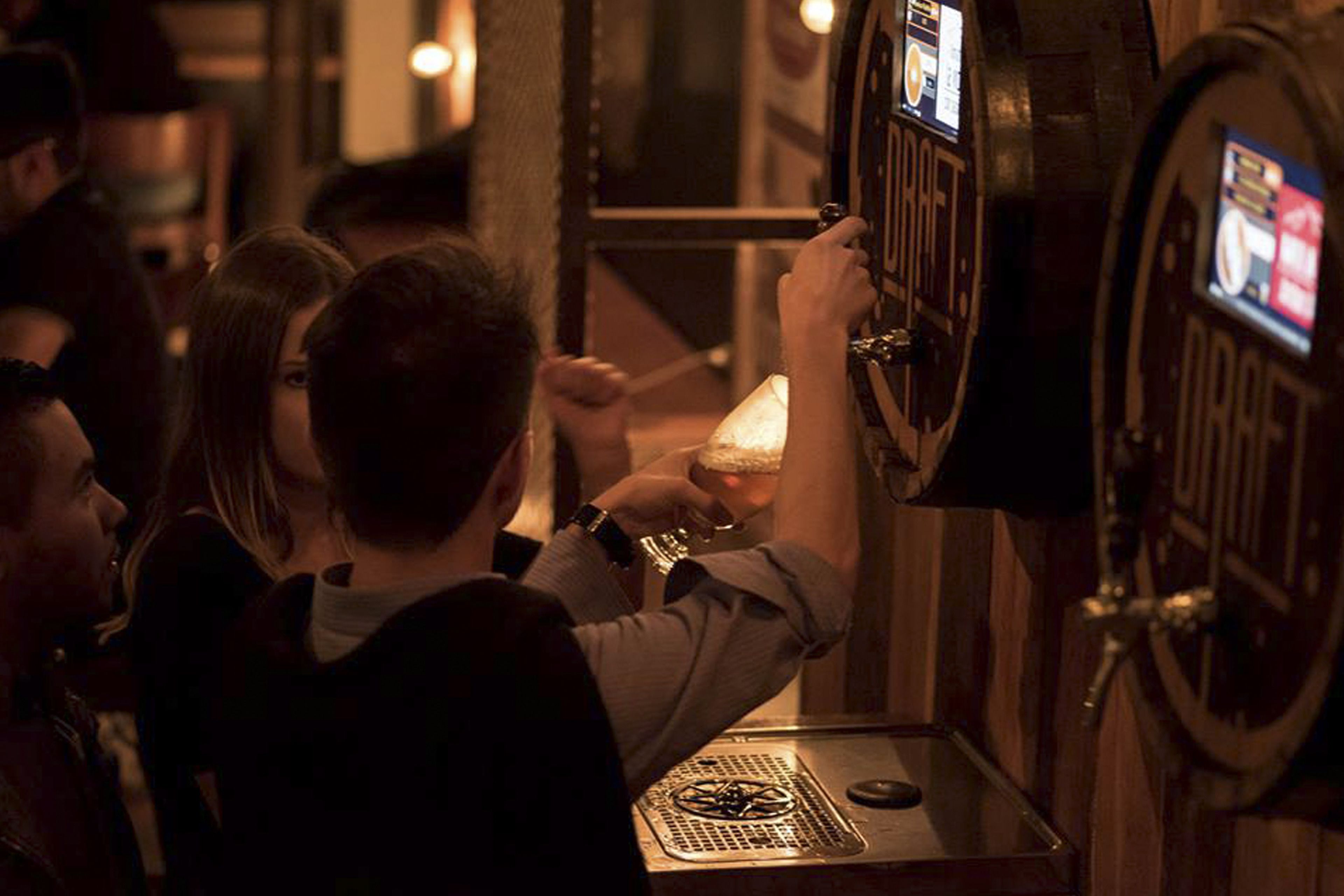 A person operating a vintage-style elevator control panel in a dimly lit room.