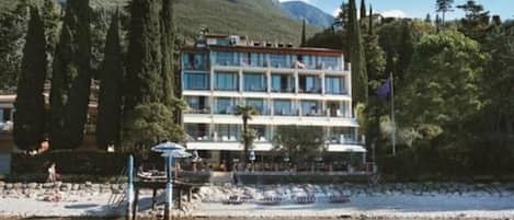 A multi-story hotel with a pool area and outdoor seating.