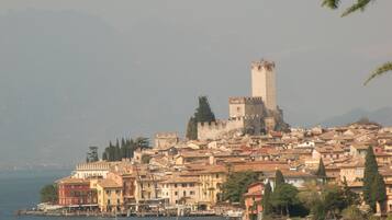Un pueblo costero con edificios históricos, una torre destacada y un puerto deportivo con barcos.