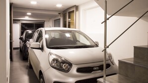 A modern interior with a white car parked in a narrow hallway leading to a staircase. - Agora Suites Self-Service Boutique Hotel (Bogotá)